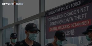 Singapore Police officers escort detained hackers during Operation Dragon Net against foreign data theft, with a banner announcing “Chinese Hackers Detained.